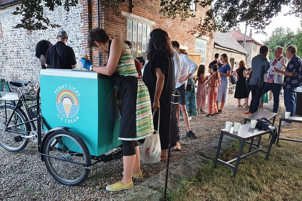 penny licks ice cream tricycle at a party