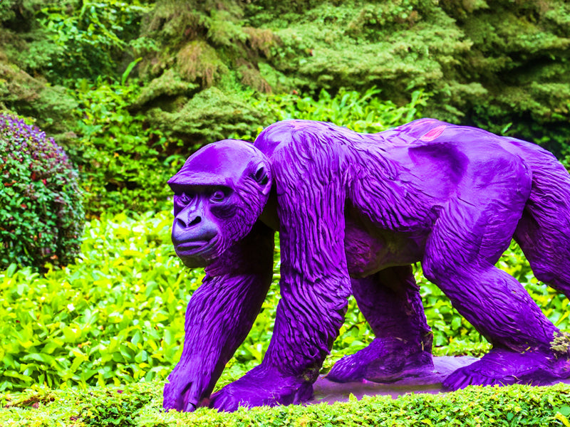 Statue de gorille violette dans jardin