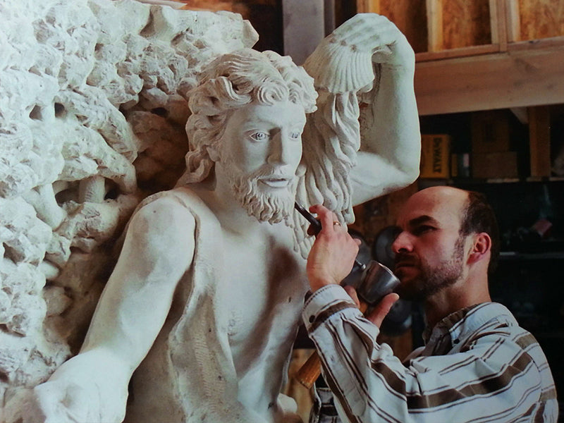 sculpteur qui sculpte une statue