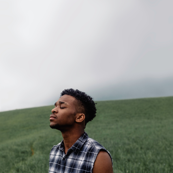 The way you process your emotions is key to emotional health. Man closing eyes looking to sky in field