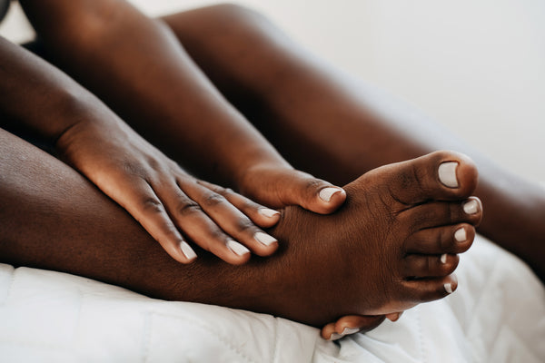 Woman moisturising her feet 