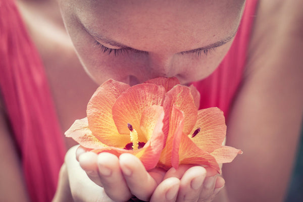 Aromatherapy can help your emotional health. Girl smelling flower for emotional health