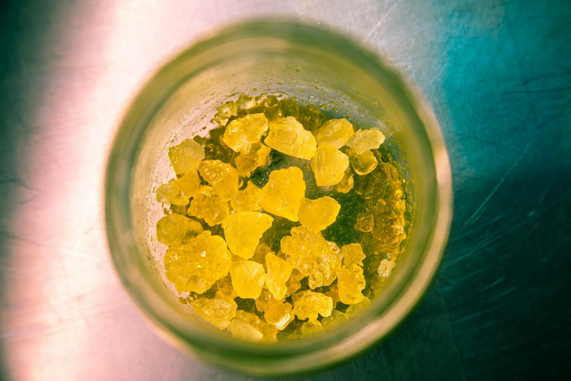 Glass of cannabis concentrate illustrating differences of shatter vs wax
