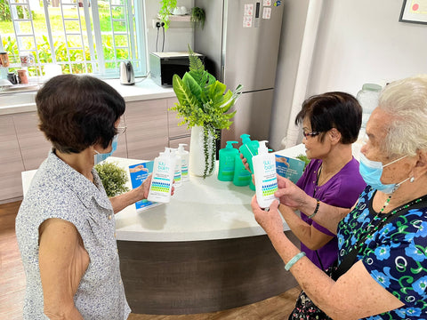 Seniors at THK Active Ageing Centres reading about Suu Balm products