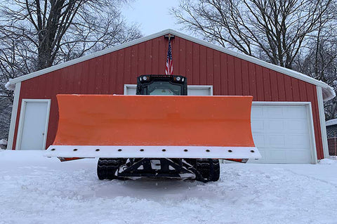 A second image of a snowplow with the same plastic used to make C&A Pro skis positioned in front of a building