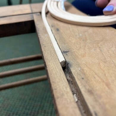 Reed Spline being inserted into a chair groove vertically to show how it must be installed.