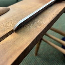 Acrylic nail file being used in chair groove to sand groove of the chair.