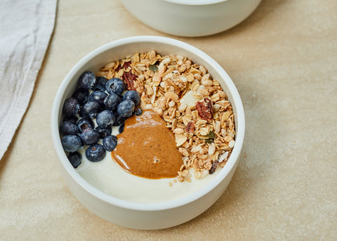 A tasty breakfast with yogurt, peanut butter, granola and fruit!