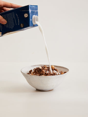 Milk poured onto bowl with chocolate lover granola