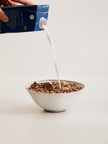 Bowl con Chocolate Lover Granola e latte versato