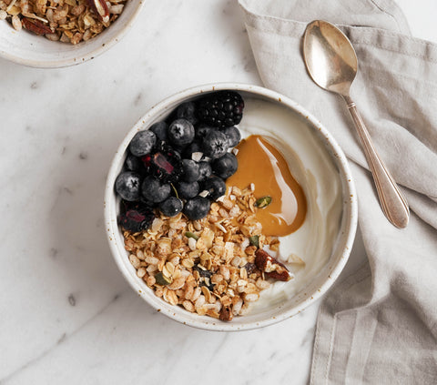 Bowl with yogurt, peanut and cinnamon cream, berries and original granola