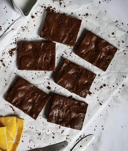 Brownies al cioccolato con due coltelli e asciugapiatti 