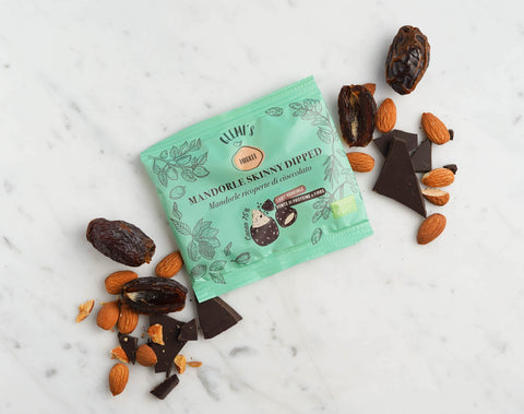 Skinny dipped almond pack with dates, almonds and dark chocolate on a marble background