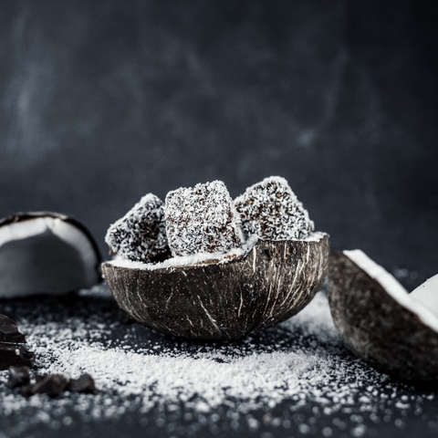 Dolce al cocco con scaglie di cocco su sfondo nero