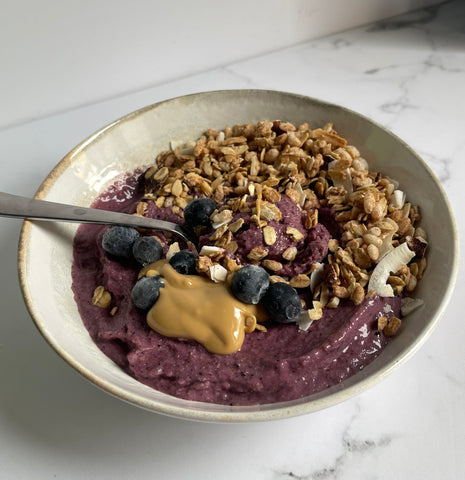 Bowl with berry smoothie, original granola, blueberries and peanut butter