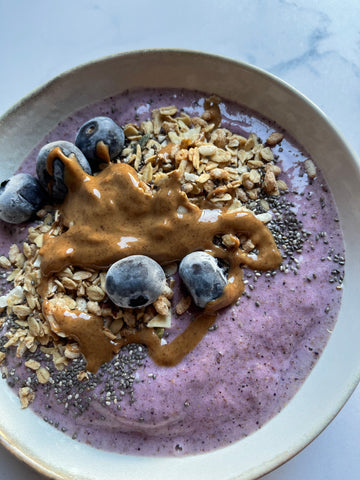 Ciotola con smoothie bowl ai frutti di bosco con semi, mirtilli e burro di arachidi zoommata