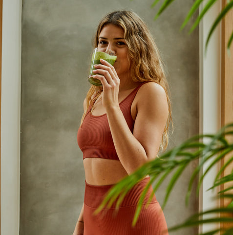 Girl drinks a smoothie in a sports suit