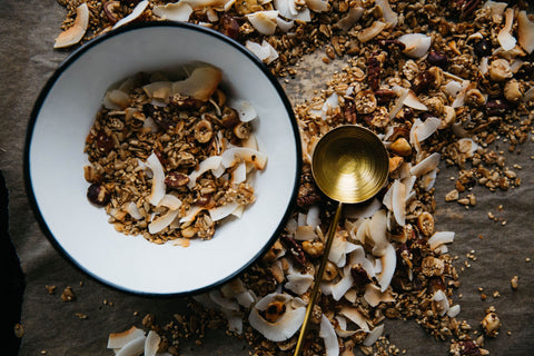 White bowl with cereal, coconut flakes, with golden spoon