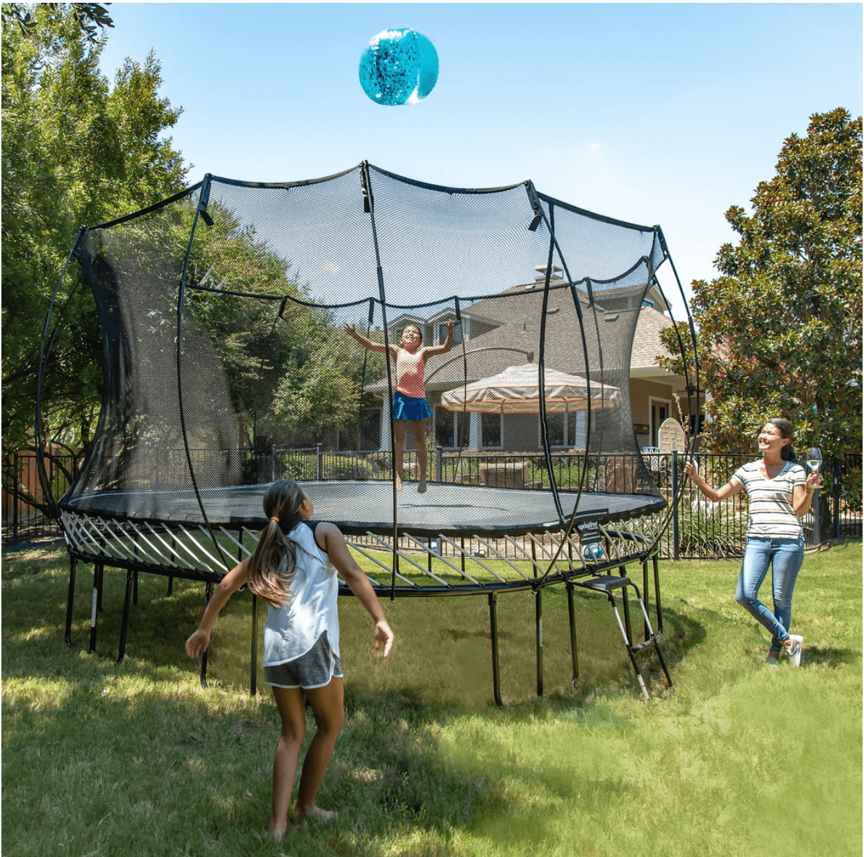 A family playing and jumping on a trampoline.