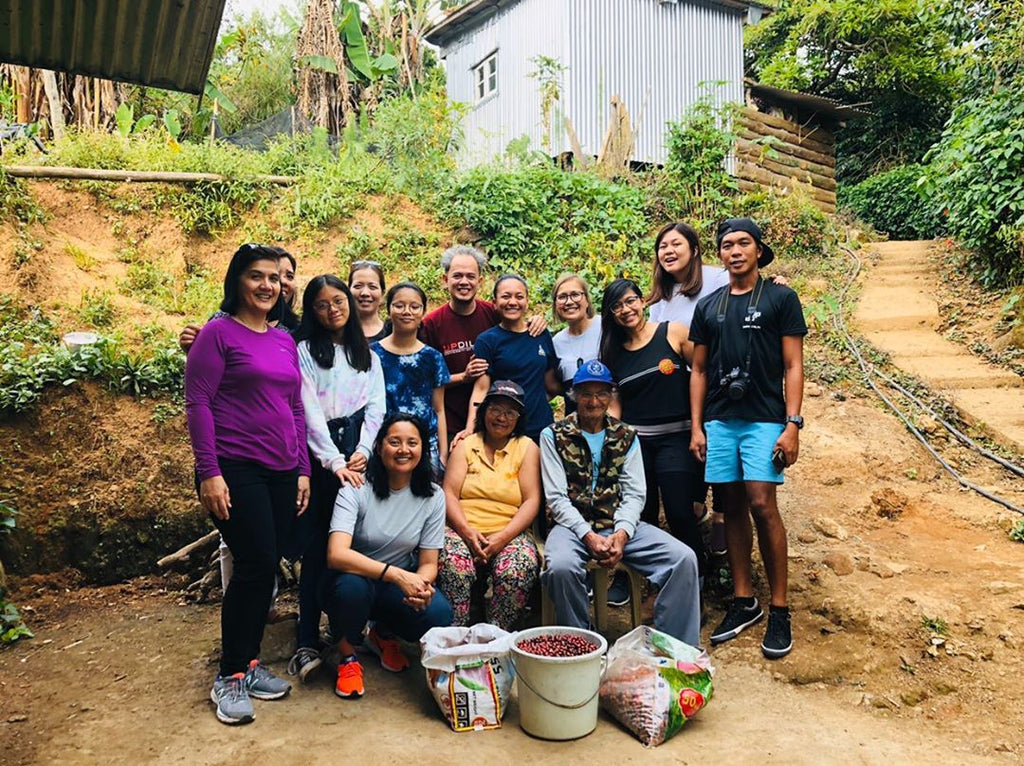 Founders of Kapé Philippine Coffee, Iona and Paolo Fresnoza, posing with Manang Mina and Uncle Ernesto (seated, centre and right) with coffee harvest volunteers from the Philippines, Canada, and the US