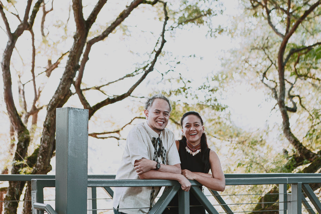 Iona and Paolo Fresnoza leaning against a bridge railing, smiling. Photo by Issha.