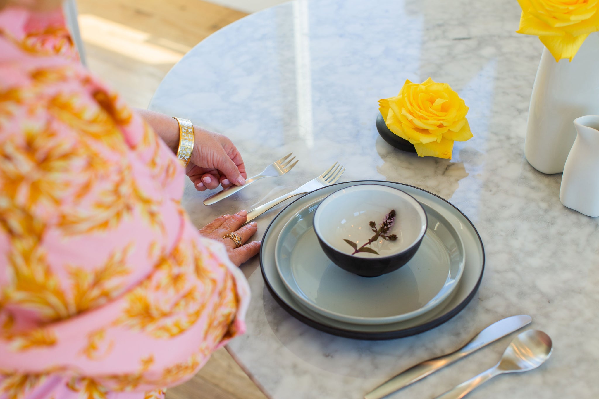 Arminé placing a fork alongside other cutlery and plates