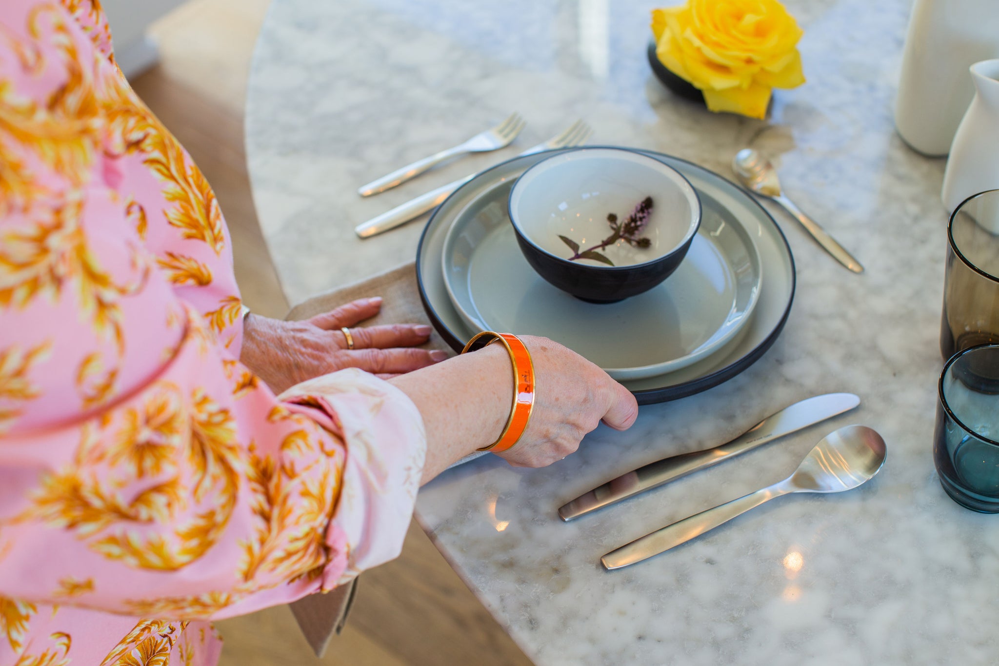 Arminé placing a table napkin beneath the plates for a modern table setting.