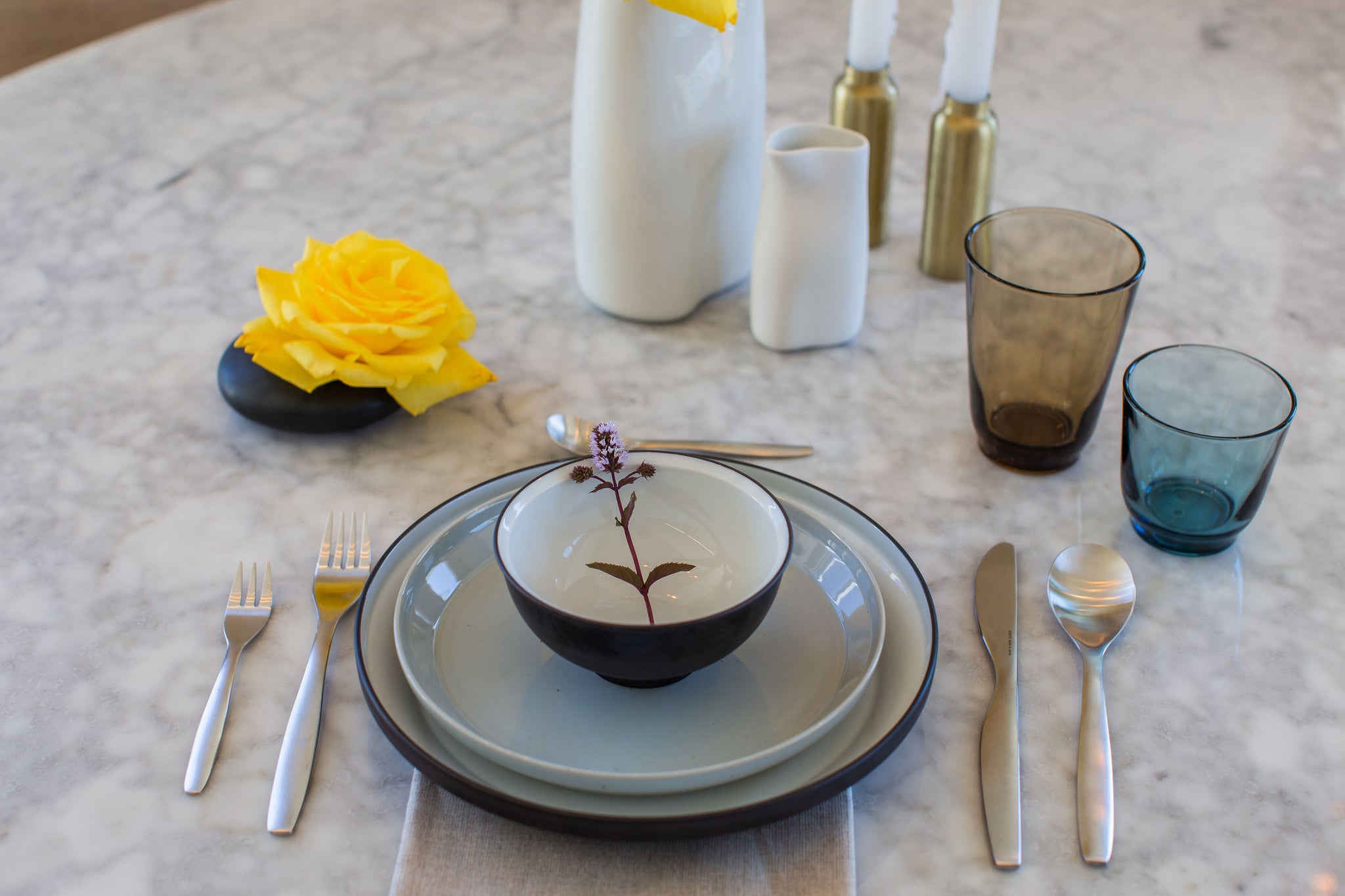 Casual table setting including Kinto glasses, flatware, and plates