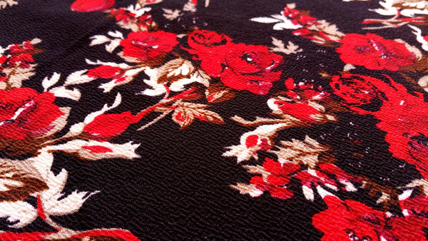 Close up of dark fabric with red roses on it