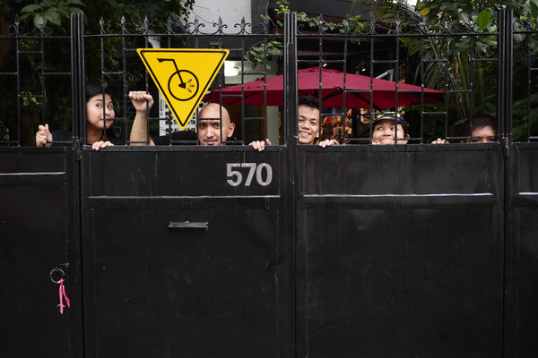 Goofy group picture of our team with only our heads visible peering out through the shop's entry gate