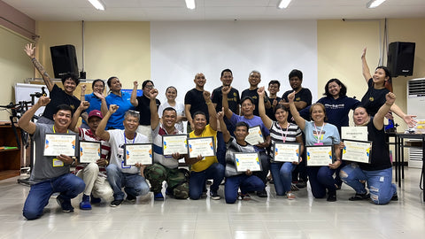 Bike Mechanic Trainees coming from SOS Children's Village communities around the Philippines, hold their Certifcates of Completion Ride Safe Bike Mechanic Workshop; celebrating alongside team members from Tambay Cycling Hub, Allianz PNB, and SOS Children's Villages.