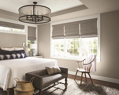 bedroom with painted walls, a king bed with fresh linens, and a chair below the window