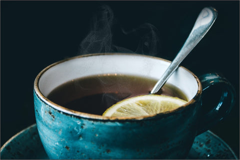 A Ceramic Cup Filled with Black Tea and a Lemon Slice 