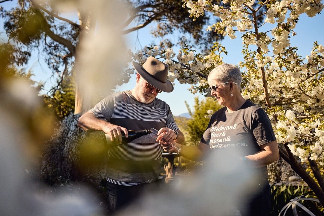 Michael and Lyn Rochford taste sparkling wine in the garden of the vineyard