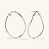 Figure Oversized Hoops: Handcrafted sterling silver earrings with unique curves and white sapphire gemstones, reflecting a design inspired by slow, intentional movement.