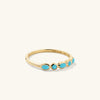 Bezel Turquoise Half Eternity Ring: a handcrafted 14k yellow gold ring adorned with vibrant turquoise gemstones, perfect for adding a beachy touch to your look.