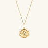 Blossom Pendant Necklace: A handcrafted 18k gold vermeil necklace featuring a round pendant with intricate floral designs, hanging on a delicate gold chain.