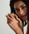 Woman's hand adorned with the Dôme Figure Ring, showcasing its unique curves inspired by slow, intentional movement. Close-up emphasizes the ring's detailed design.