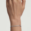 Hand wearing the Flat Curb Chain Bracelet, a sleek and versatile silver accessory, enhancing the overall look with its elegant design.