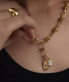 Person wearing a gold Texture Tag necklace, featuring intricate designs, suitable for layering or as a standalone heirloom piece.