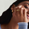 Close-up of a woman's hand wearing the Patra Ring, a handcrafted 14k gold ring with a triangle design.