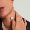 Close-up of a woman's neck and hand showcasing the Diamonds Band, a handcrafted 14k solid gold ring with diamonds, highlighting its elegance and intricate design.