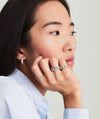 Woman's hand resting on chin, showcasing a Pavé Diamond Soft Charlotte Ring, featuring 72 diamonds set in 14k gold.