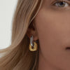 Close-up of a woman's ear wearing Stevie Hoops, featuring interchangeable and reversible gold and silver links for customizable fashion.