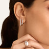 Close-up of a woman's ear adorned with Block Small Hoops, showcasing modernist, angular design.