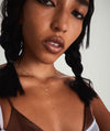 A woman with braids wearing a Mini Heart Pavé Diamond Necklace, posing for a close-up photo.