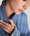Close-up of a woman's hand showcasing the Pavé Diamond Soft Charlotte Ring in 14k gold, encrusted with diamonds, worn with a denim jacket.