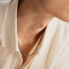 Person wearing the Round Box Chain Necklace, featuring a delicate, balanced design suitable for everyday wear. Close-up highlights the necklace as a fashion accessory.