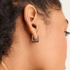 Close-up of a woman's ear wearing Block Small Hoops, angular earrings inspired by modernist architecture, highlighting their sleek, everyday design.