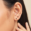 Close-up of a woman's ear wearing the Pos - Straight Bar Spheres Flat Back Stud, showcasing the elegant, minimalistic design of the earring.